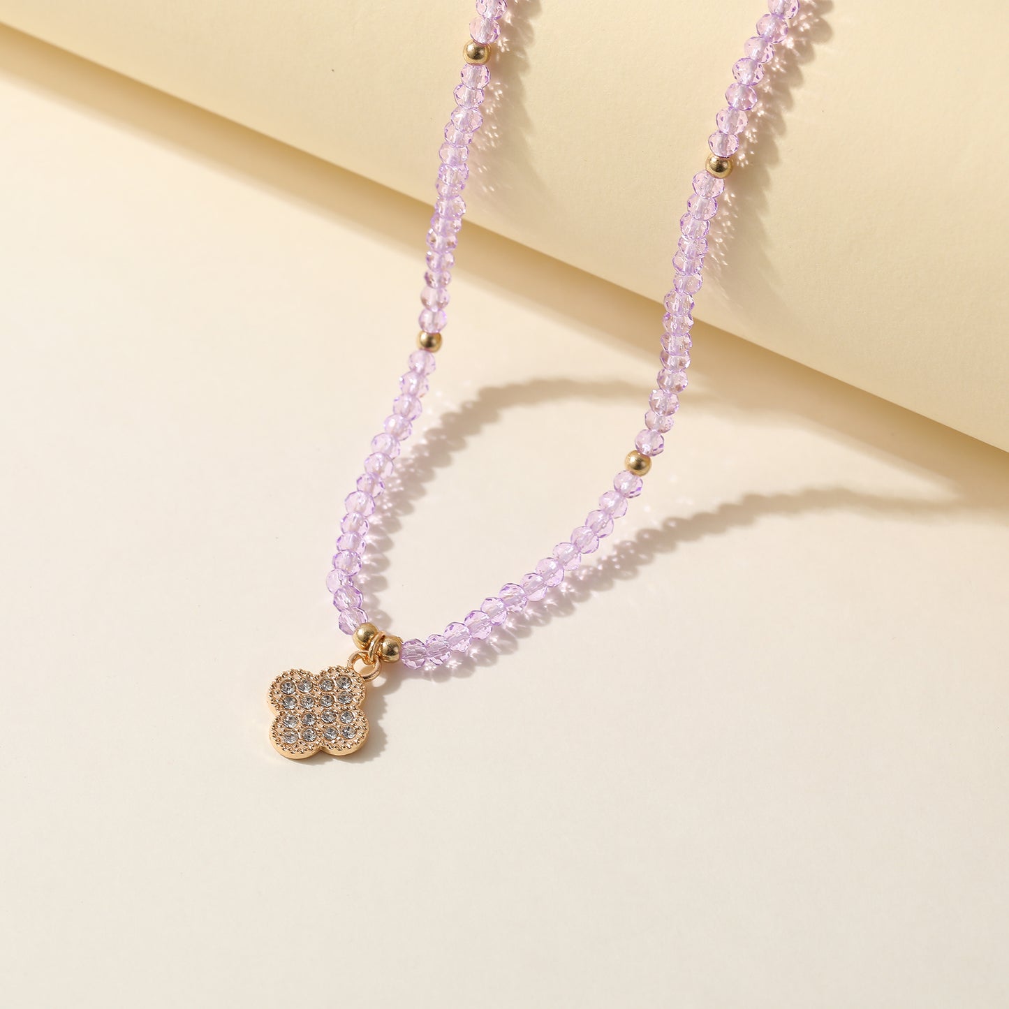 Elegant Beaded Necklace with Crystal & Gold Clover Charm - Stylish Jewelry for Women in Black, Purple, White & Pink